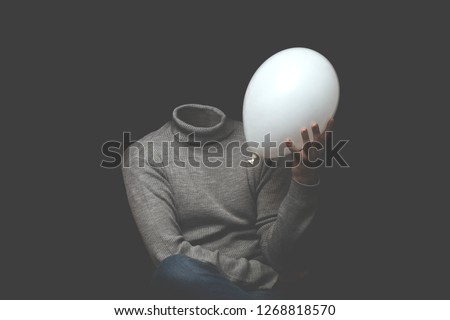 man without head holding white balloon