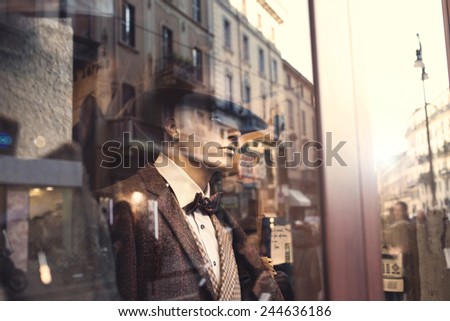 well dressed Man behind a window watching people in the street