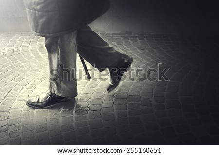 Old Man walking with his stick toward light