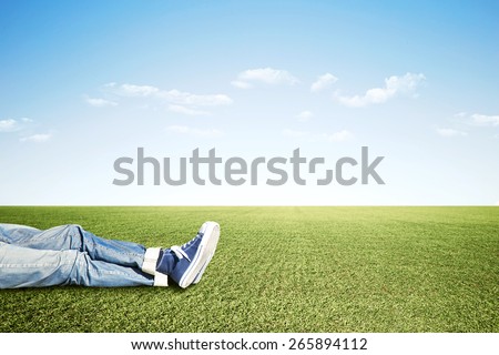 Lazy man lying on the grass doing nothing