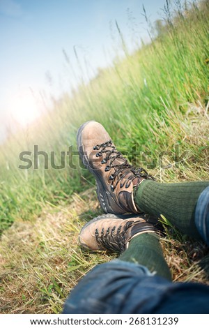 hiker lying down resting in the grass with trekking boots