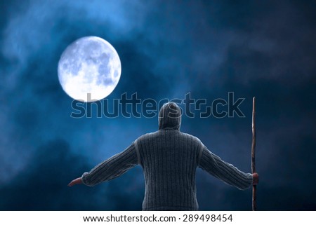 Man hiking in the night under big shining moon