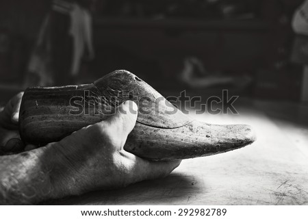 old hands hold old wood shoes model size