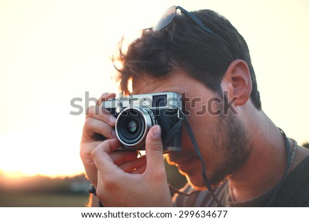 Man shooting with vintage camera at sunset