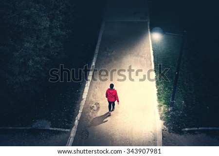alone girl walking in the park in the night