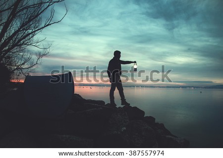 Man with a torch camping in the lake at night