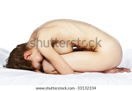 stock photo nude young woman covering her face with her arms laying on bed