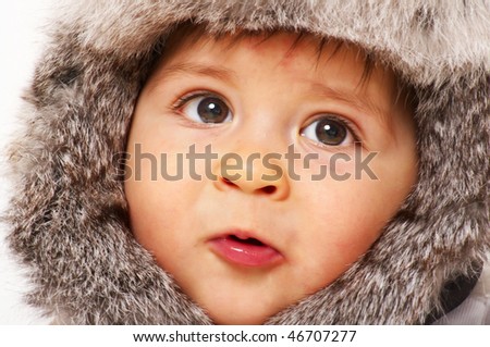 baby boy in fur cap looking surprise; closeup face