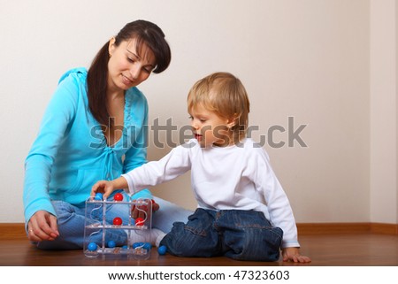 mother helping son put the toy