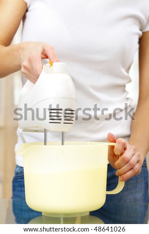 cook preparing cream using a kitchen mixer