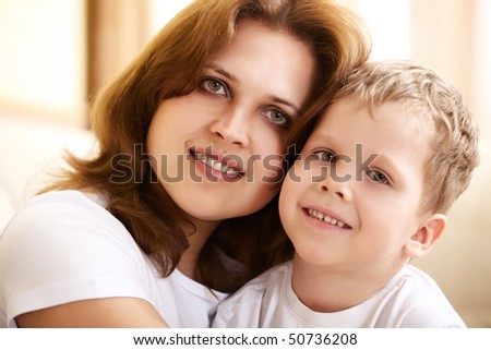 happy young mother hugging her little son at home