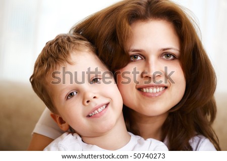 happy young mother hugging her little son indoor