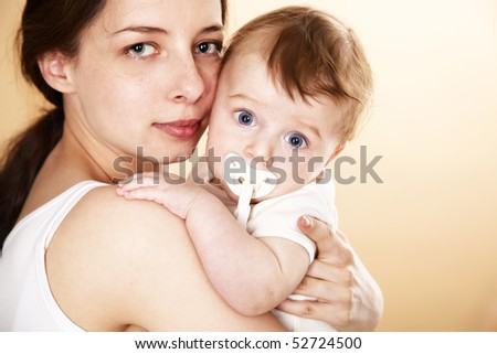 baby with pacifier in mother arm; closeup faces