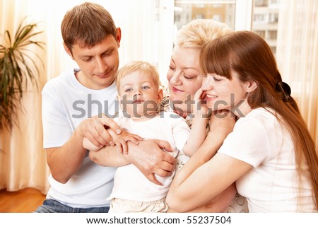 mother, father and grandmother playing with child indoor