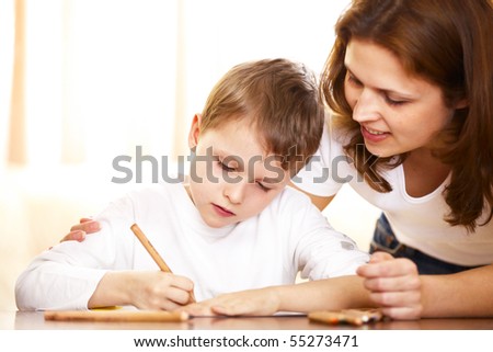 mother helping with homework to her son indoor
