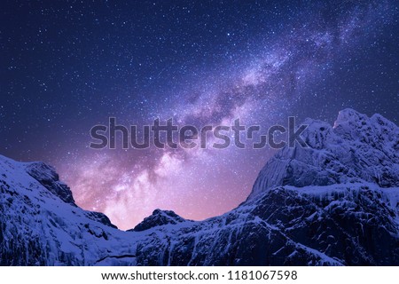Milky Way above snowy mountains. Space. Fantastic view with snow covered rocks and starry sky at night in Nepal. Mountain ridge and sky with stars in Himalayas. Landscape with purple milky way. Galaxy