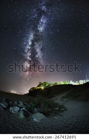Milky Way. Beautiful summer night sky on the beach in Ukraine. Trail and stone