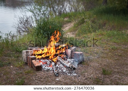 Bonfire in the spring forest. Coals of fire. Twilight in Ukraine