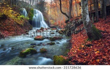 Beautiful waterfall in autumn forest in crimean mountains at sunset. Silver Stream Waterfall in Grand Canyon Of Crimea.