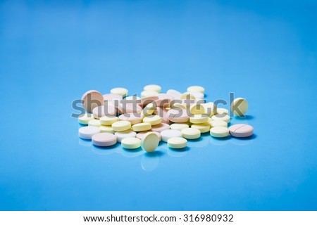 Medicine pills or capsules on blue background. Drug prescription for treatment medication. Pharmaceutical medicament, cure in container for health. Antibiotic, painkiller closeup.