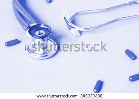 Medical, medicine stethoscope and pills on blue background. Health care or illness. Tablet or drug in hospital or pharmacy. Cardiology heart treatment. Medication prescription for medication, therapy