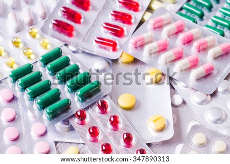 Medicine green and yellow pills or capsules on white background. Drug prescription for treatment medication. Pharmaceutical medicament, cure in container for health. Antibiotic closeup