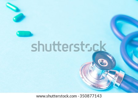 Medical, medicine stethoscope and pills on blue background. Health care or illness. Tablet or drug in hospital or pharmacy. Cardiology heart treatment. Prescription. Toned effect