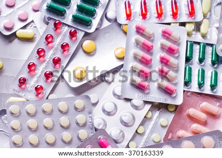 Medicine green and yellow pills or capsules on white background with copy space. Drug prescription for treatment medication. Pharmaceutical medicament, cure in container for health. Antibiotic closeup