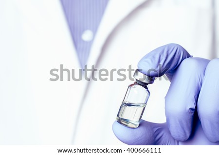 Medicine bottle for injection in hand, palm of a doctor. Medical glass vial for vaccination. Science equipment, liquid drug or vaccine from treatment, flu in laboratory, hospital or pharmacy.