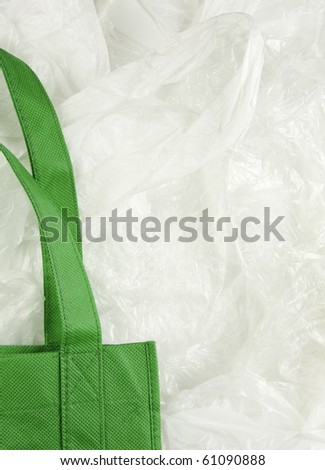 Green, eco shopping bag contrasting against disposable plastic bags.