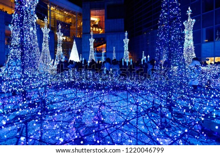 Night scenery of Winter Illumination Display in a pedestrian square in Caretta Shiodome Shopping Area, Tokyo, Japan, with decorated Christmas trees and dazzling lights in a romantic dreamy atmosphere