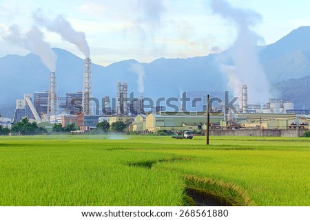 Factory in the middle of a green farmland on a cloudy day