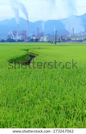 Factory in the middle of a green farmland on a cloudy day