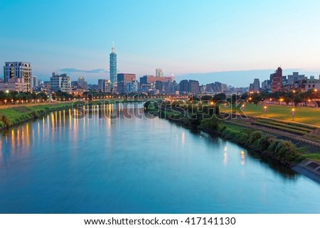 Night view of Taipei City by riverside with skyscrapers and beautiful reflections on smooth water ~ Landmarks of Taipei buildings, Keelung river, Xinyi district and downtown area at dusk