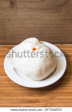 Closeup of the  steamed dumpling on white dish with wood background