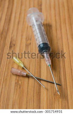 Closeup of the syringe on the wood background