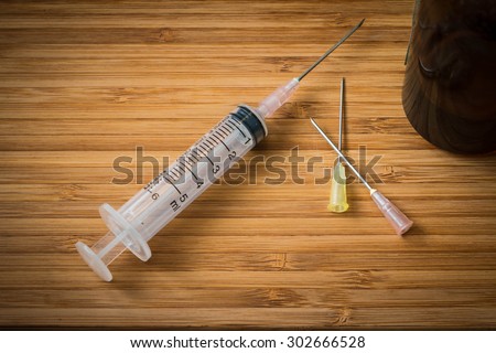 Closeup of the syringe on the wood background
