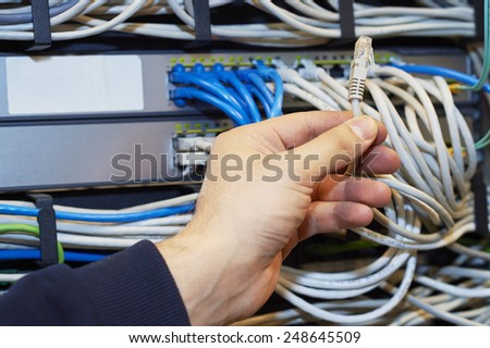Technician is cutting wires using pliers of server in data center