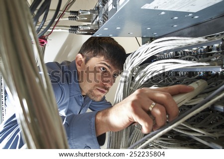 Technician is checking server\'s wires in data center
