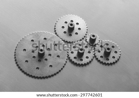 Five metallic gears on black and white