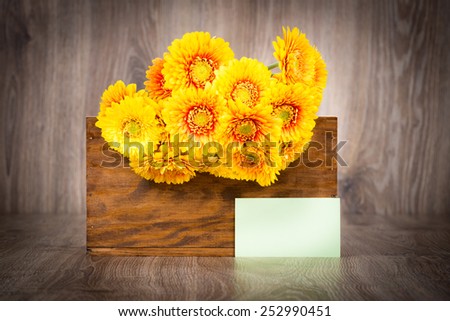 Bouquet of daisy flowers in the box on wooden background