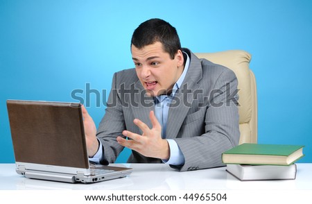 Angry businessman at work on blue background