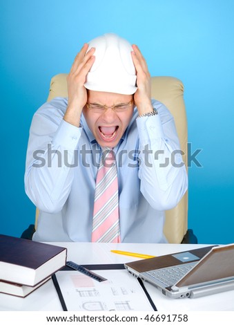 Crazy engineer with white hard hat at work on blue background