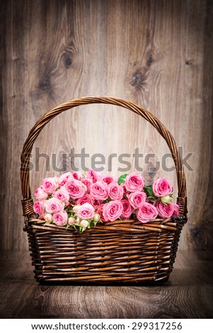 Roses in the basket on wooden background