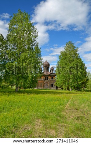 Abandoned wooden Church on the green meadow,birch, blue cloudy sky at the origins of the Kama river