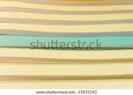 some yellow books and one green isolated on white background