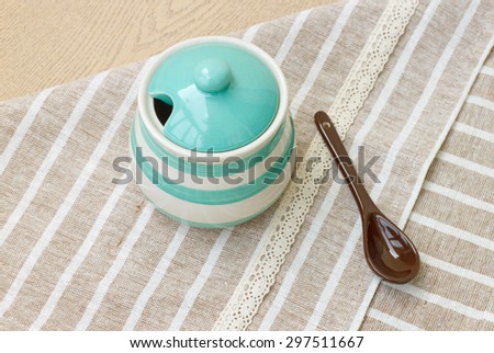 Green pastel porcelain jar and brown spoon with cute fabric.