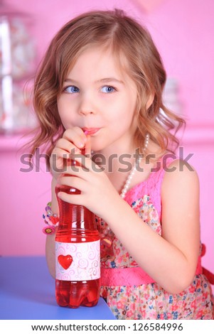 Portrait of a beautiful girl in a floral dress drinking juice in a restaurant celebrating