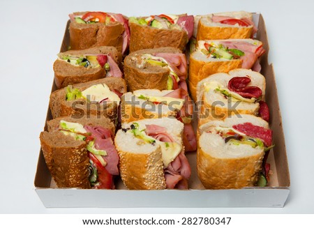 Sandwiches in box on white background. Assorted delicious baguette sandwiches. Various kinds of sandwiches