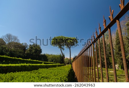 FLORENCE, ITALY - APRIL 14, 2013: Rusty metal fence and trimmed bushes in Boboli Gardens. Florence, Tuscany, Italy.